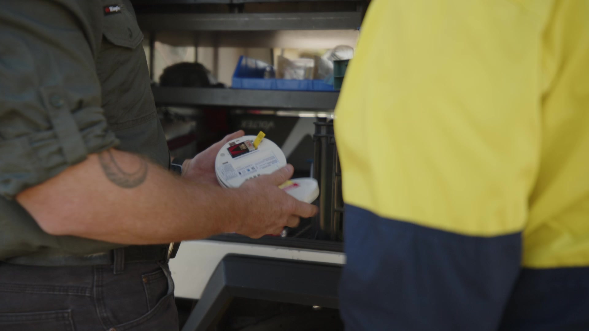 Keagan and an electrician inspecting a smoke alarm during fault-finding